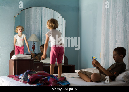 Brother and sister playing on their bed at the Guesthouse Sancti Spiritus Cuba Stock Photo