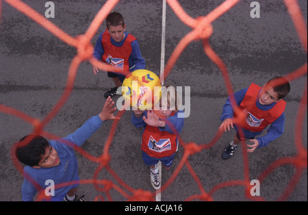 Primary school children playing basketball in school playground, Middlesex, UK. Stock Photo