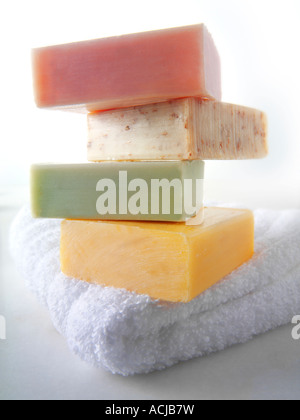 4 bars of hand made natural scented soap bars piled up on a white face towel Stock Photo