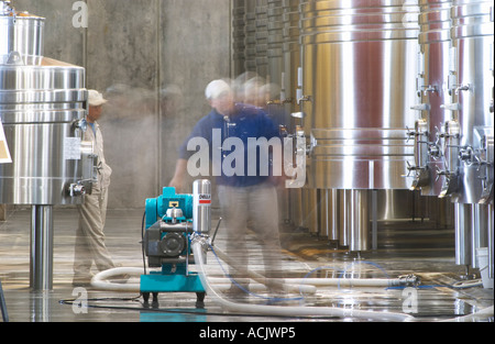 View over the winery, stainless steel fermentation tanks. Winery workers with a pump pumping from one tank to another. Bodega NQN Winery, Vinedos de la Patagonia, Neuquen, Patagonia, Argentina, South America Stock Photo