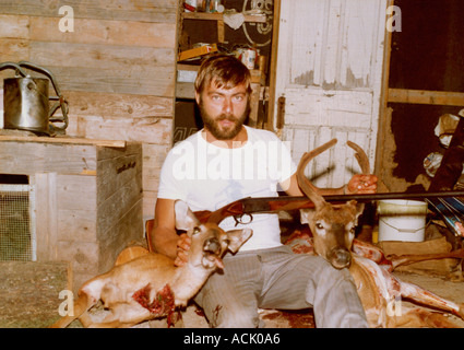 A hunter posing next to two dead deer Stock Photo