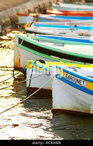 Typical Provencal fishing boats painted in bright colours white, blue, green red yellow, moored at a jetty Le Brusc Six Fours Var Cote d’Azur France Stock Photo