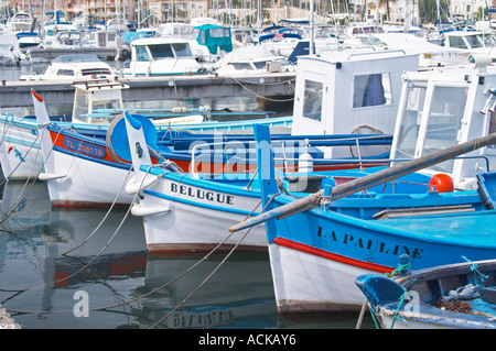Typical Provencal fishing boats painted in bright colours white, blue, green red yellow, moored at the keyside Sanary Var Cote d’Azur France Stock Photo
