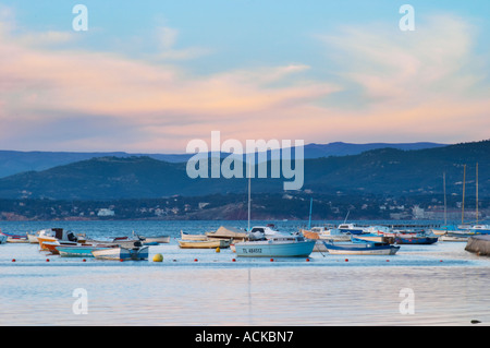 View from Sanary over the sea towards the mainland mountains at sunset, light faded blue, Provencal boats moored at buoys in the water Le Brusc Six Fours Var Cote d’Azur France Stock Photo