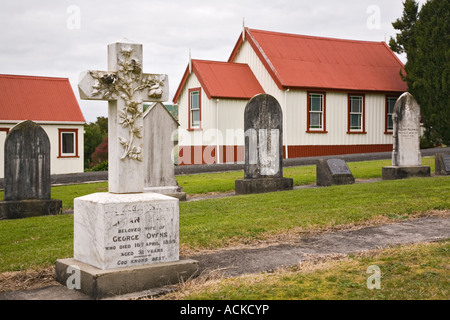 The Kauri Museum original pioneer church 1867 grave yard with ornate old stone cross headstone Matakohe Northland North Island Stock Photo