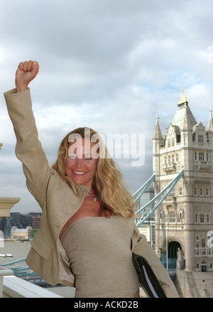 a well dressed business woman celebrating success Tower Bridge backdrop Stock Photo