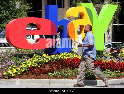 ebay headquarters in San Jose California, an employee carries a computer in front of the ebay logo Stock Photo