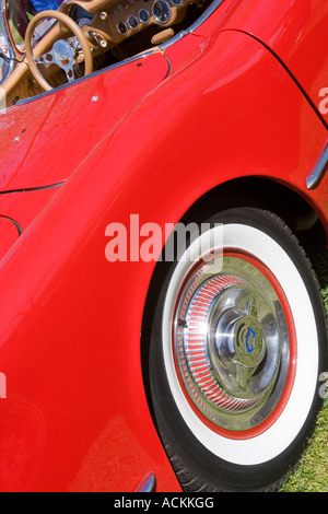 Rear wheel and steering wheel of a bright red 1954 Chevrolet Corvette convertible classic car at an auto show Stock Photo