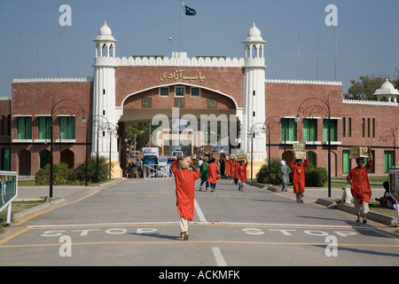Pakistani porters carry goods through the Wagah Gate, on the border with  India Stock Photo