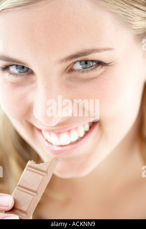 A young woman eating chocolate close up Stock Photo