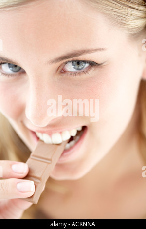 A young woman eating chocolate close up Stock Photo