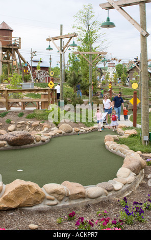 Family playing miniature golf while vacationing in Pigeon Forge ...