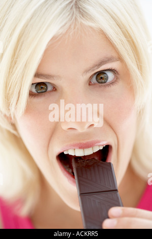 A young woman eating a bar of chocolate Stock Photo