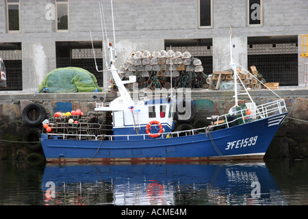 Blue fishing boat trawler in the harbour at Viverio Spain Stock Photo