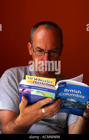 Man Reading travel book British Columbia Stock Photo
