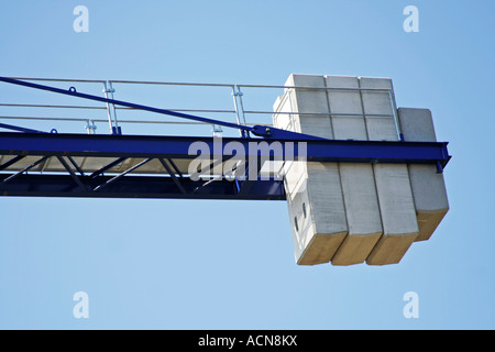 isolated view of the counterweight at the end of a crane platform against a blue sky. Stock Photo