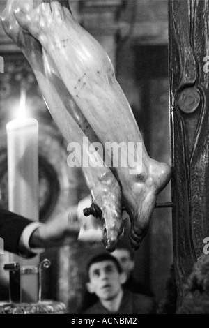 Worshipper cleaning feet of Christ of Calvary Stock Photo