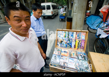 Chinese Man Selling Fake Counterfeit DVDs on the Street Shanghai China Stock Photo