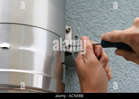Craftsman working on chimney - Kaminbefestigung festziehen Stock Photo