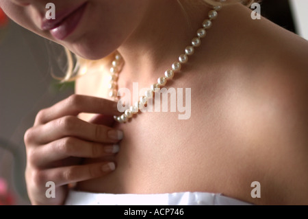 woman's hand touching pearl necklace Stock Photo