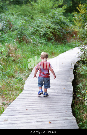 Small boy walking on pathway into future Life Stock Photo