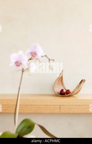 Fruit bowl with apple on shelf and orchid Stock Photo