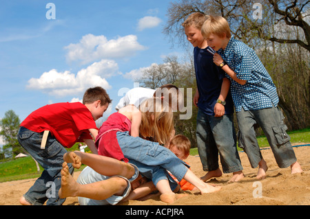 Children (6-9) play fighting on playground Stock Photo - Alamy