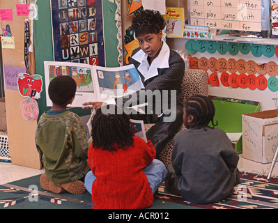 high school student reading to small children Stock Photo