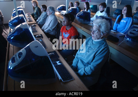 Kids and seniors in a computer class where children help older folks use computers Stock Photo