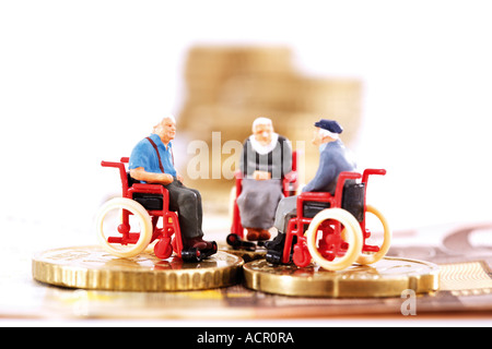 Figurines in wheelchairs on coins Stock Photo