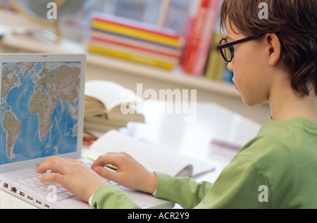 Boy (8-9) using laptop, side view Stock Photo