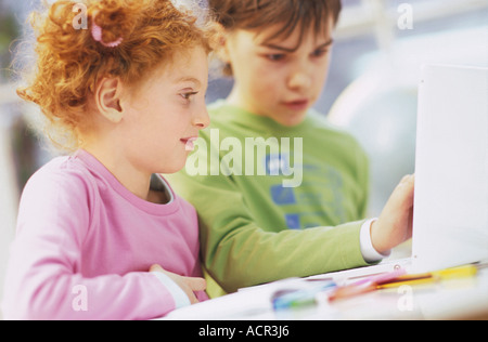 Boy and girl (7-9) using laptop Stock Photo