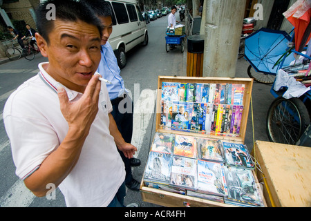 Chinese Man Selling Fake Counterfeit DVDs on the Street Shanghai China Stock Photo