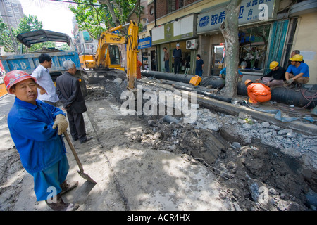 Chinese Workmen using Hyundai Heavy Equipment for Roadwork in Shanghai China Stock Photo