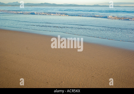 a nice beach scene with gentle waves reaching the sand Stock Photo