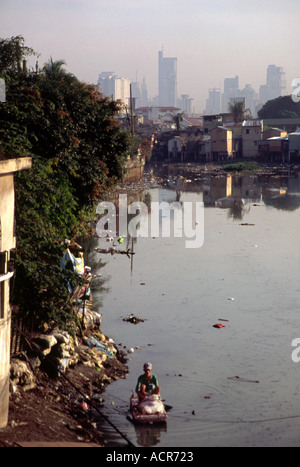 Man paddling in polluted creek 2 Manila Philippines Stock Photo