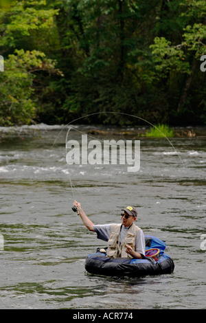 Fishing with a float tube. The man is sitting in the fishing inflatable  boat and he use flippers to move on the water Stock Photo - Alamy