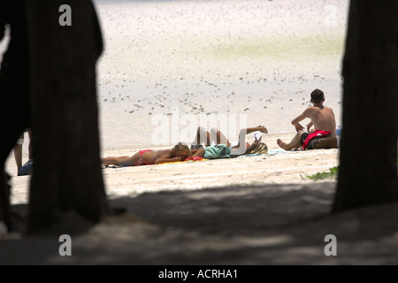 Young people sitting on Hat Sai Ri beach Ko Tao island Thailand