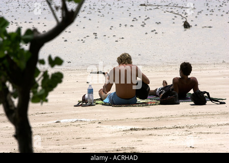 Young man plays guitar on Hat Sai Ri beach Ko Tao island Thailand