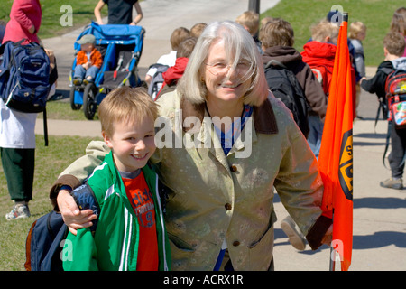 Teacher with favorite student taking kids to buses and parents cars. Horace Mann Elementary School St Paul Minnesota USA Stock Photo