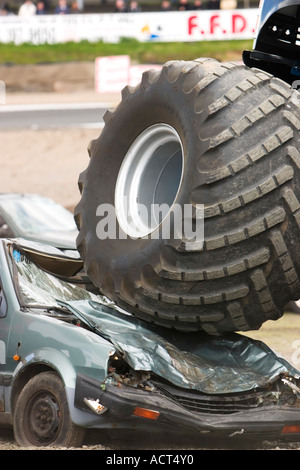 Massive wheel of Grim Reaper monster truck crushing car at Knockhill Motorfair 2006 Stock Photo