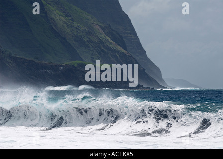 Foamy waves breaking on Kalaupapa leper colony beach with tall sea cliffs on Molokai Hawaii Stock Photo