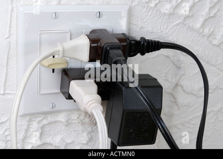 Overloaded Electrical outlet and light switch with no room for more plugs Stock Photo