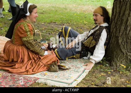 A COUPLE IS SITTING UNDER TREE IN ROMANTIC MOOD Stock Photo