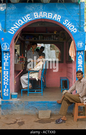 View of a barber shop in Orchha with a local man being shaved and one waiting outside. Stock Photo