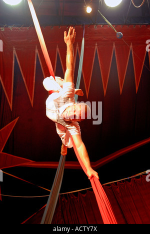 Circus acrobat performer tangled in red drapes Stock Photo