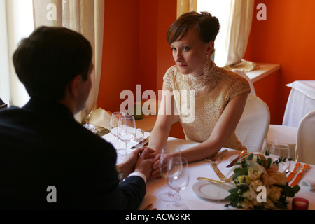 Bride and Groom at their wedding reception sat at table in love Stock Photo