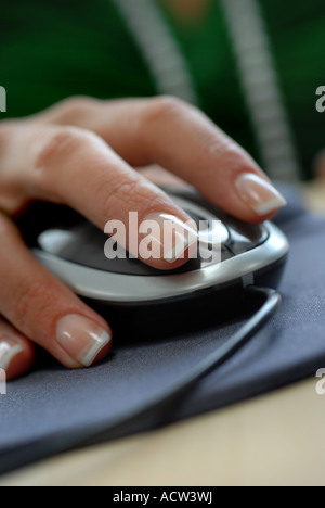 Womans hand using a computer mouse with scroll wheel in an office Stock Photo