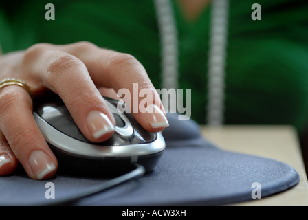 Womans hand using a computer mouse with scroll wheel in an office Stock Photo
