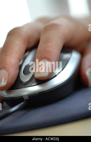 Womans hand using a computer mouse with scroll wheel in an office Stock Photo